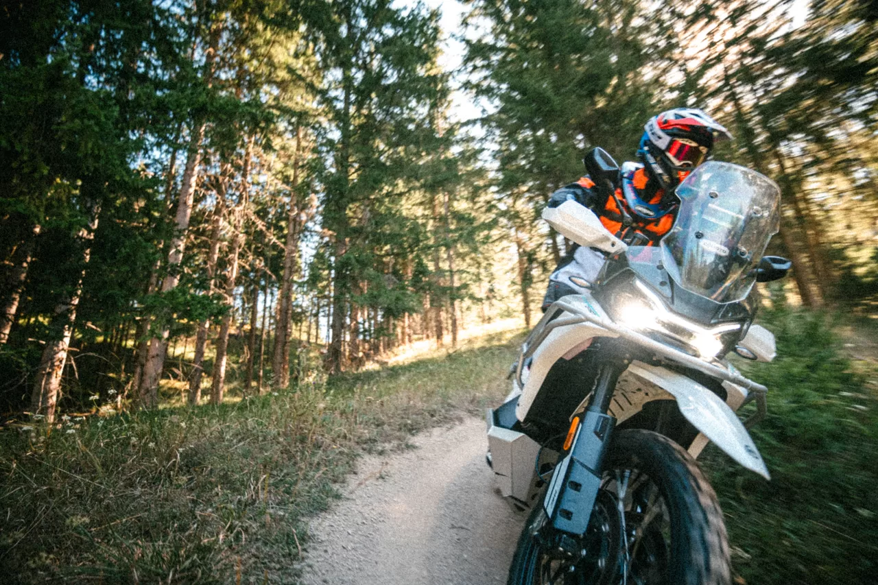 Fahrer auf einem weißen Adventure-Motorrad bei der Anfahrt auf die Kamera