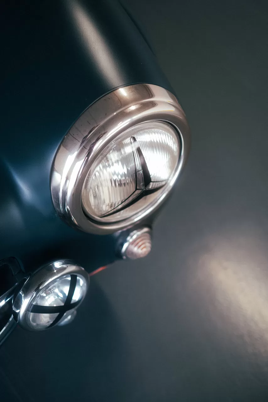 Nahaufnahme eines Oldtimer-Scheinwerfers im dunklen Parkhaus