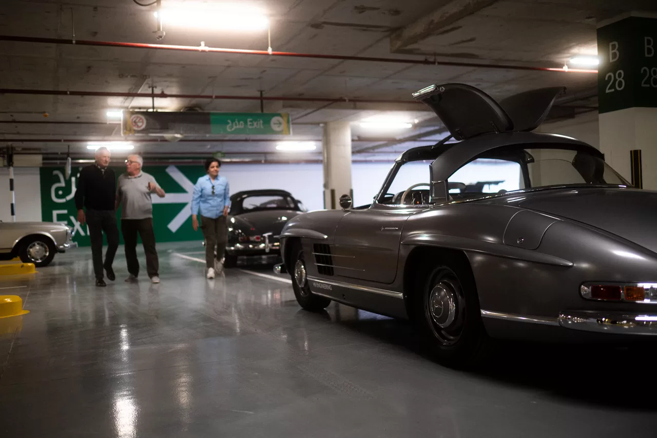 Rallye-Teilnehmer neben einem Mercedes 300 SL im Parkhaus